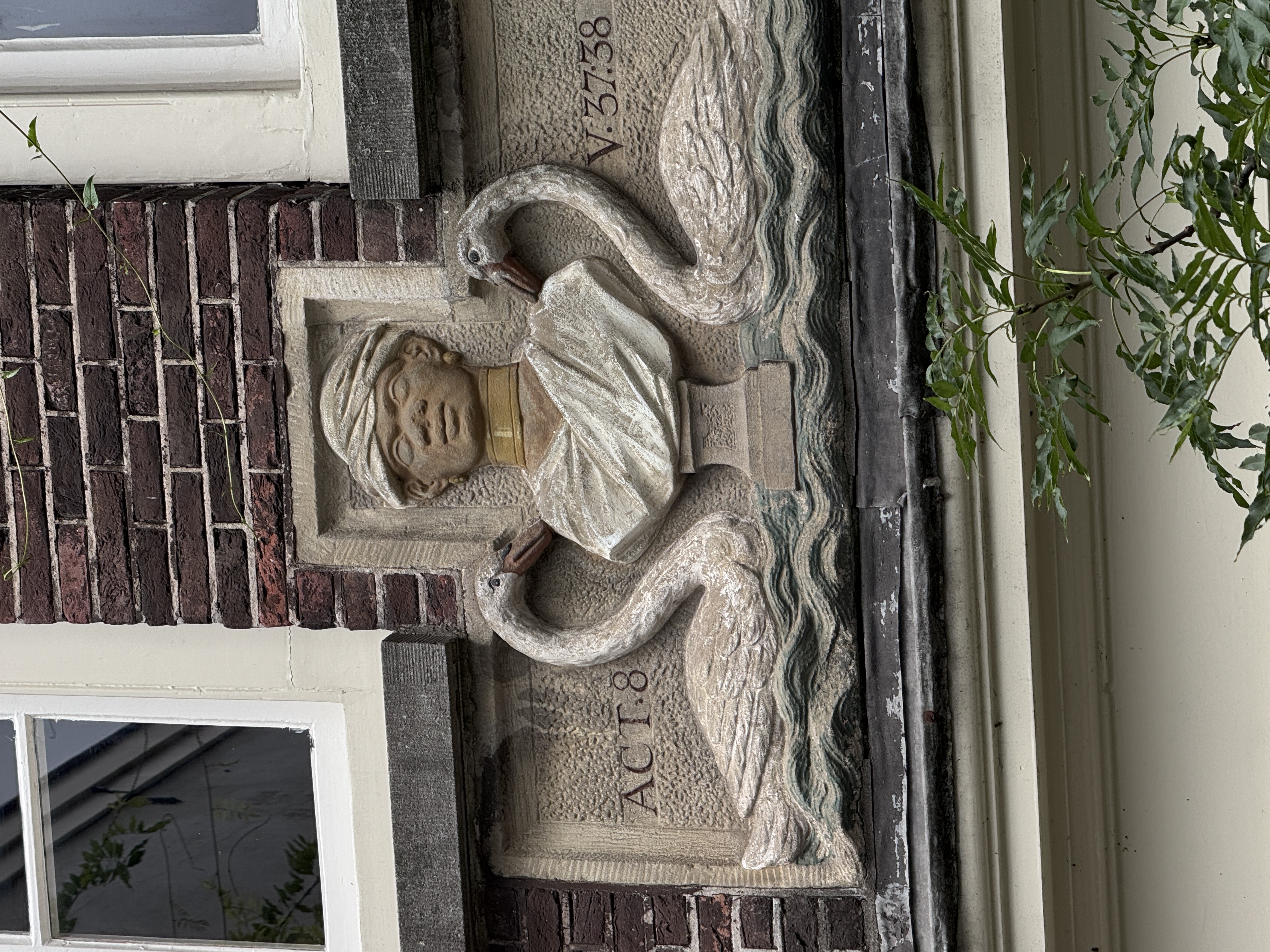 Gevelsteen met Moriaanshoofd, zwanen en de verwijzing Act. 8 vers 37 en 38